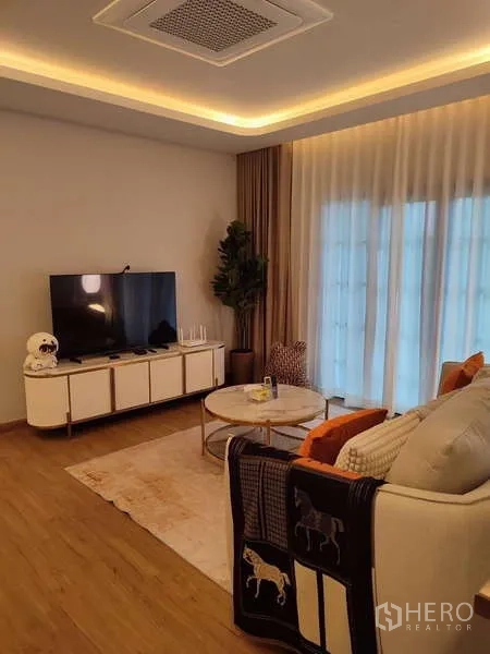 Detached House for rent in Bang Phli, Samut Prakan - Family lounge with TV unit, sofa, wood flooring and tall curtains.