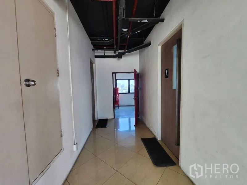 Retail Space for rent in Bang Rak, Bangkok - Hallway with tiled floor, exposed pipes, and access to restrooms.