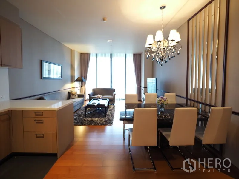 Condominium for rent in Sathon, Bangkok - Open-plan living and dining area with chandelier, hardwood floors and full-height windows.