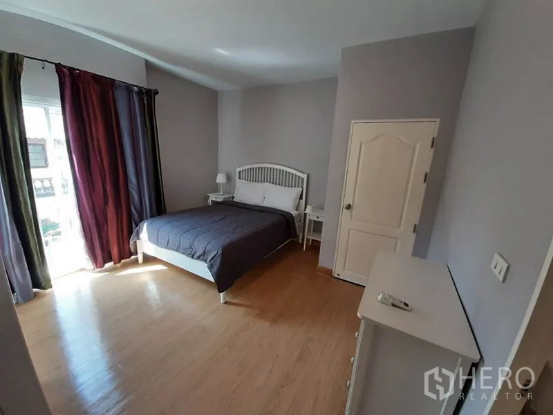 Condominium for sale in Wang Thonglang, Bangkok - Spacious master bedroom with double bed, side tables and large windows.