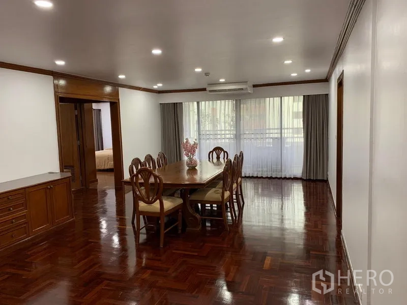 公寓 出租在Watthana, Bangkok - 采光充足的餐厅，长木餐桌与八把椅子，毗邻大窗，位于 Liberty Park 1 公寓。