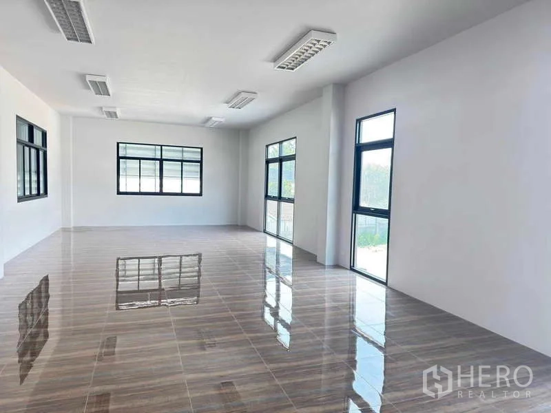 货栈 出租在Mueang Rayong, Rayong - 采光充足的办公室，大窗与亮面地砖和吊顶灯。