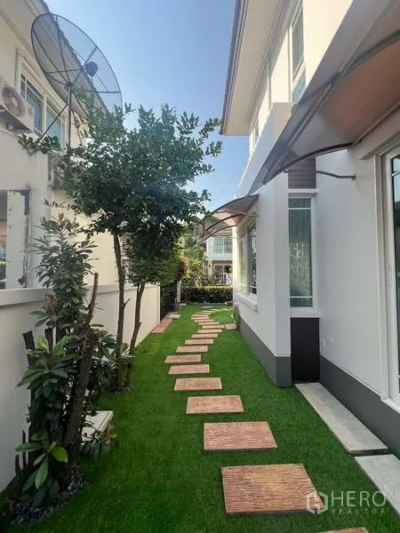 Detached House for rent in Bang Kapi, Bangkok - Lush side walkway with trees, lawn and awnings.