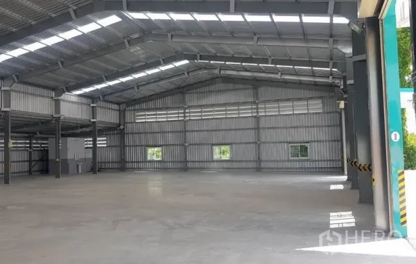 Warehouse for rent in Mueang Nonthaburi, Nonthaburi - Spacious warehouse interior with high steel trusses, skylights, and polished concrete floor.