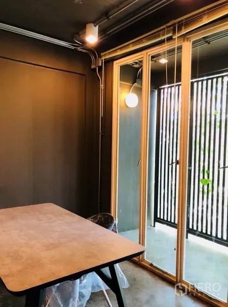 Home Office for rent in Huai Khwang, Bangkok - Private office with desk beside sliding glass doors to a balcony.