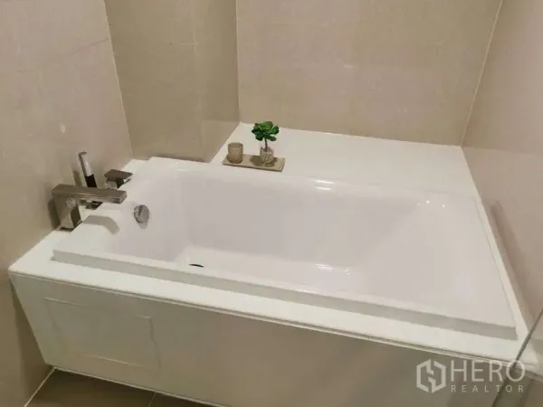 公寓 出租或出售在Watthana, Bangkok - 简洁浴缸与现代龙头，米色墙砖，摆放小绿植