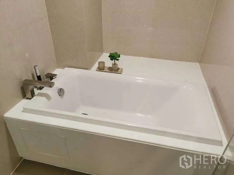 公寓 出租或出售在Watthana, Bangkok - 简洁浴缸与现代龙头，米色墙砖，摆放小绿植