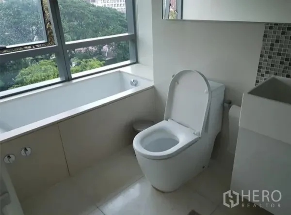 公寓 出租或出售在Watthana, Bangkok - 现代浴室，窗边浴缸与坐便器，享绿色景观与采光