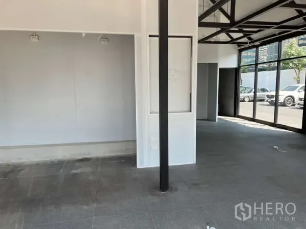 零售空间 出租 - 宽敞销售区，白色墙面、黑柱与灰色地砖。