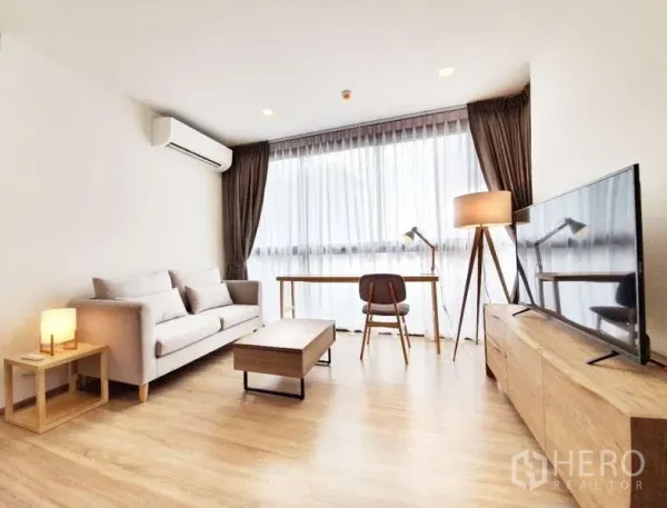 公寓 出售在Watthana, Bangkok - 宽敞客厅一角，书桌、落地灯与大幅纱帘窗户。