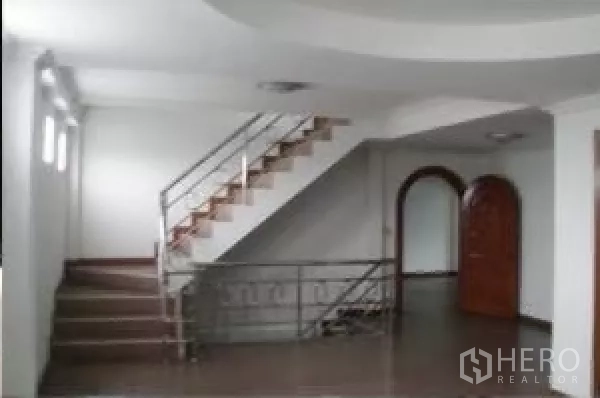 Factory for rent in Bang Phli, Samut Prakan - Interior stair hall with tiled floors, metal handrails and an arched doorway.