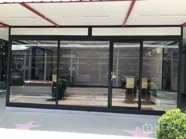 Office Space for rent in Wang Thonglang, Bangkok - Street-facing office with large black-framed windows, covered awning, and visible reception area in Bangkok.