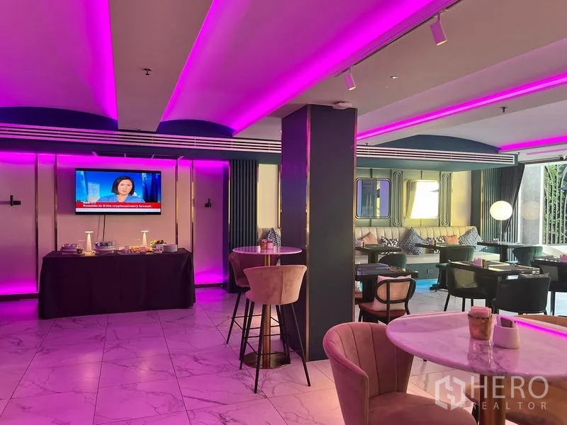Retail Space for rent - Contemporary retail lounge with pink LED ceiling, marble floors, café tables, bar stools and a TV wall.