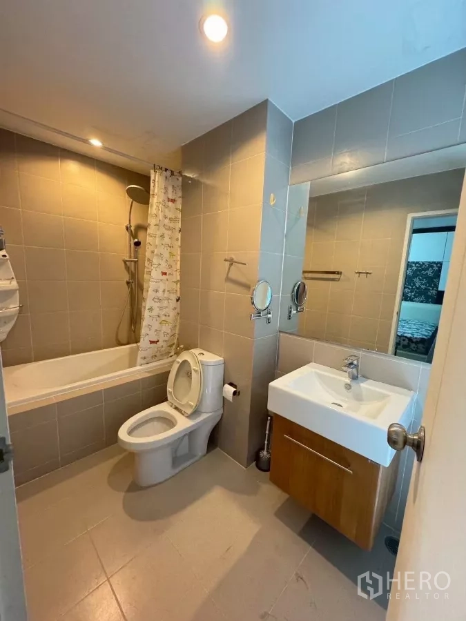 Townhouse for rent in Suan Luang, Bangkok - Bathroom with bathtub, shower, vanity and toilet in neutral tiles.