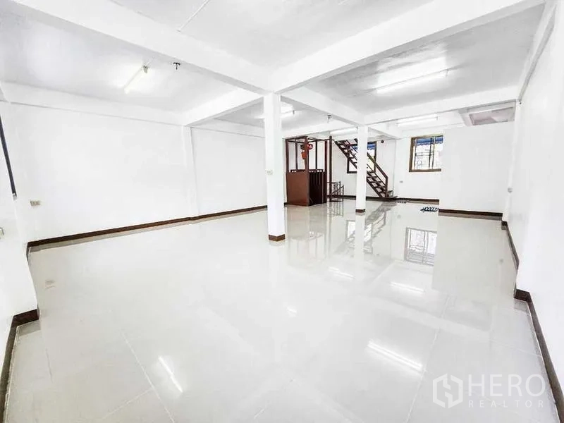 Home Office for rent in Khlong Toei, Bangkok - Expansive white hall with polished tiles and stairs leading to the upper level.