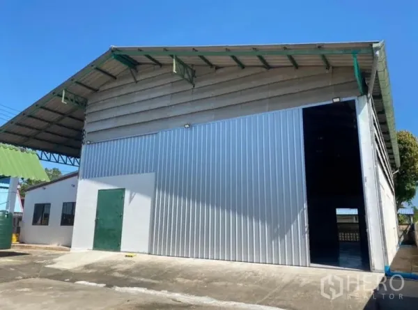货栈 出租在Mueang Rayong, Rayong - 高挑金属仓库正面，设大型滑门与侧边服务房。