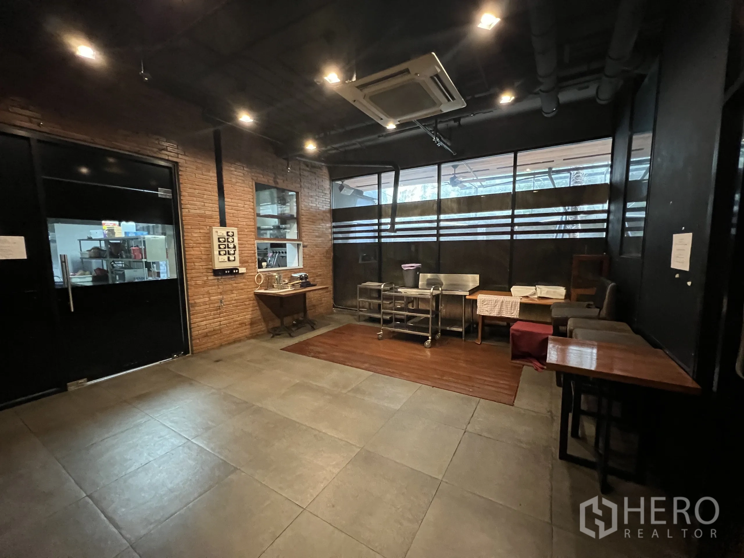 Retail Space for rent in Watthana, Bangkok - Flexible prep or private room with brick accent wall, tile floors, and kitchen access.