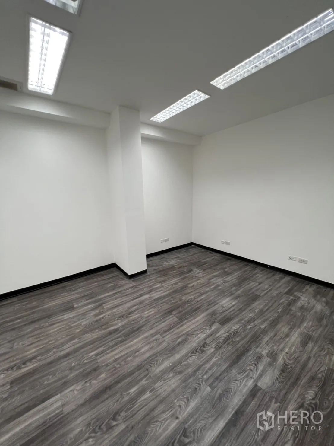 Retail Space for rent in Sathon, Bangkok - Compact white office room with strip lighting and laminate flooring.