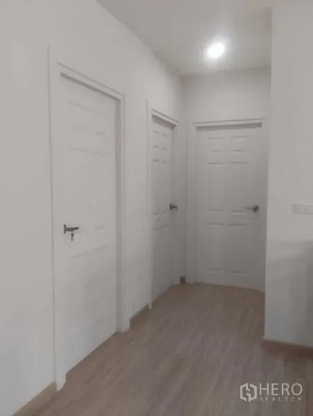 Detached House for sale in Phra Khanong, Bangkok - Bright interior hallway featuring three white doors and wood-look flooring.