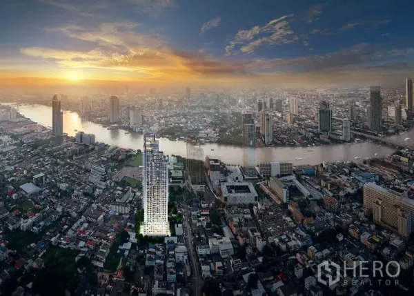 Condominium for sale in Bang Kho Laem, Bangkok - Aerial view of a riverside high-rise condominium near the Chao Phraya River with the city skyline at dusk.