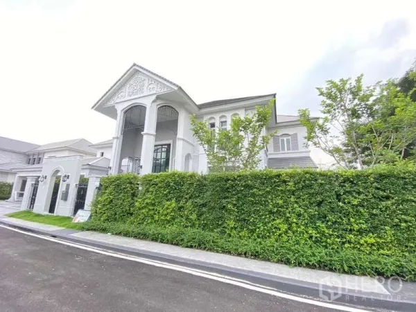 Detached House for rent or sale in Lat Krabang, Bangkok - Grand neo-classical two-storey house facade with tall columns and manicured hedges.