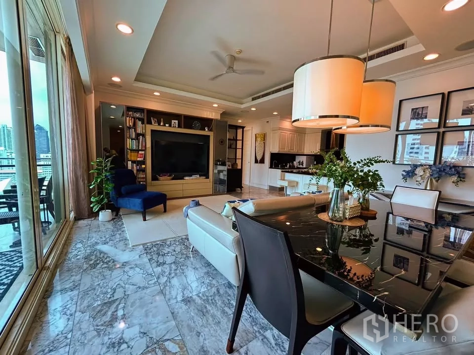 Condominium for sale in Watthana, Bangkok - Open-plan lounge and dining area with marble flooring, built-in TV wall and sliding doors to the balcony.