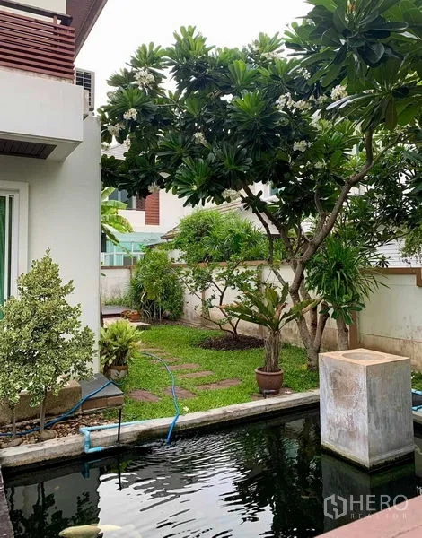 独立式住宅 出租在Prawet, Bangkok - 景观花园，成树环绕并设长方形鱼池水景。