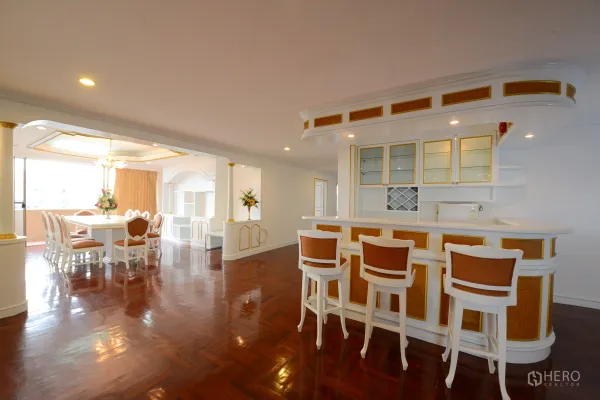 Condominium for rent or sale in Watthana, Bangkok - Open dining area and breakfast bar with white-and-gold cabinets and glossy wood flooring
