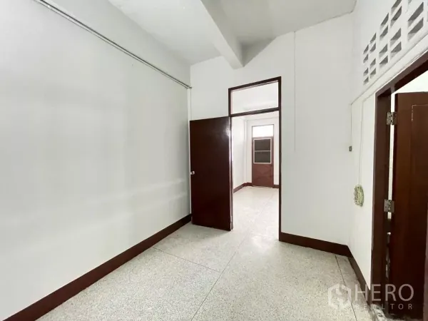 Home Office for rent in Din Daeng, Bangkok - Compact room with terrazzo floor and wooden doors, suitable as a bedroom or workspace.