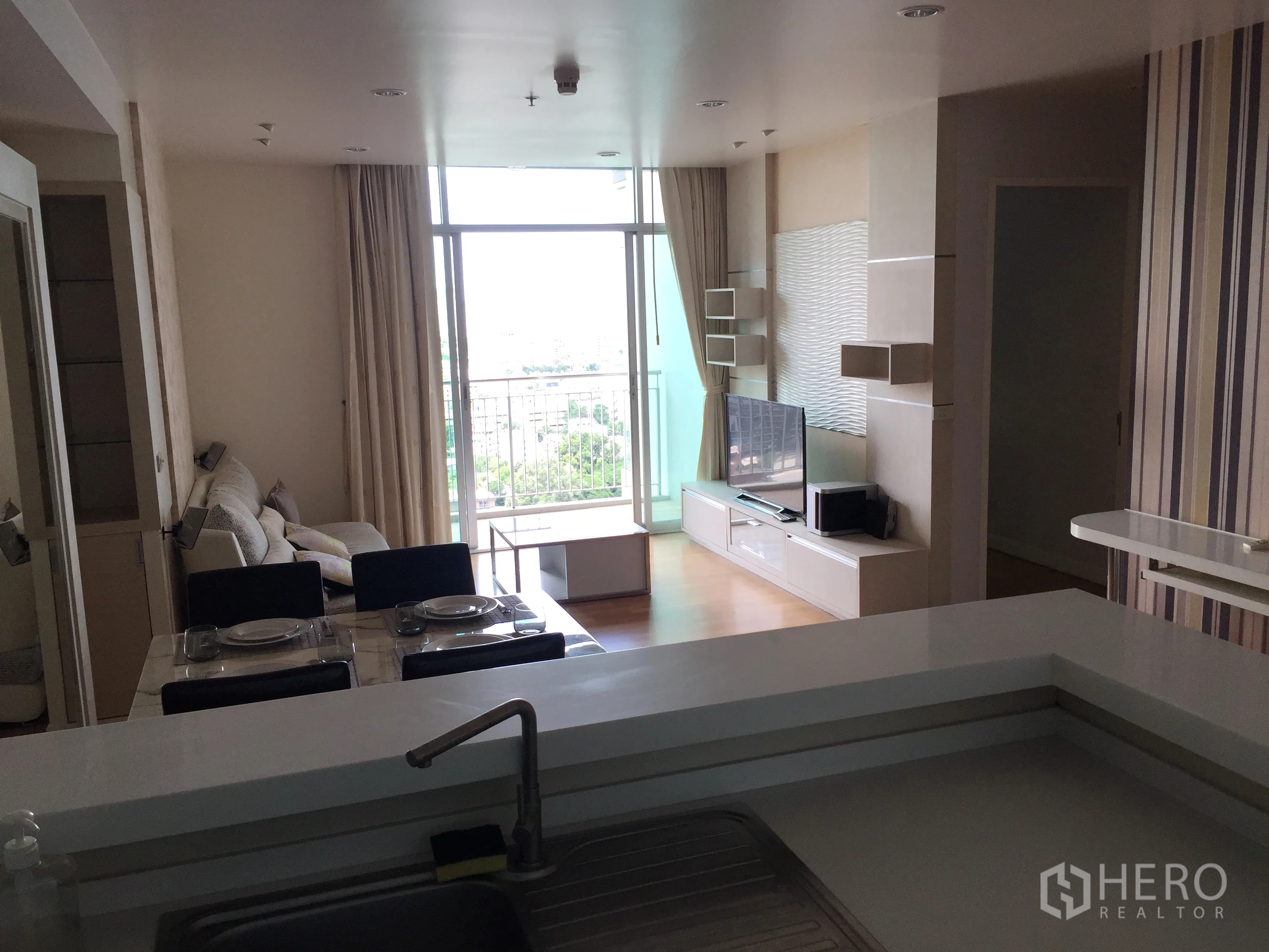 คอนโด ให้เช่าหรือขายในSathon, Bangkok - โซนรับแขกและทานอาหารแบบเปิดโล่ง พร้อมตู้วางทีวีและประตูกระจกออกสู่ระเบียงรับแสงธรรมชาติ