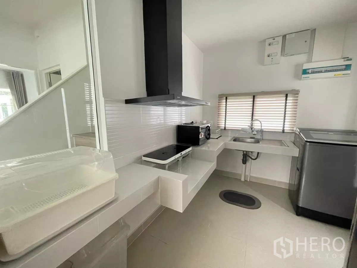 บ้าน ให้เช่าหรือขายในBang Phli, Samut Prakan - ครัวปิดขนาดกะทัดรัด มีเตา เครื่องดูดควัน อ่างล้างจาน และเครื่องใช้ไฟฟ้าข้างหน้าต่าง