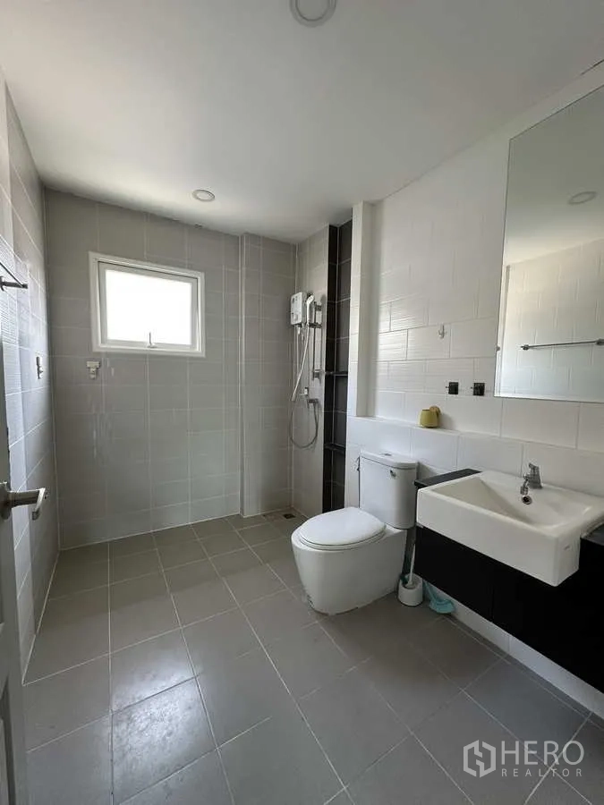 Detached House for rent in Khlong Luang, Pathum Thani - Upstairs bathroom with water heater, shower and window ventilation.