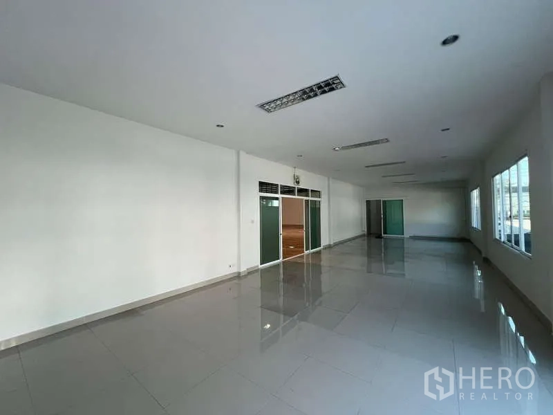 Warehouse for rent in Prawet, Bangkok - Open-plan office floor with glass partitions and glossy tile flooring.