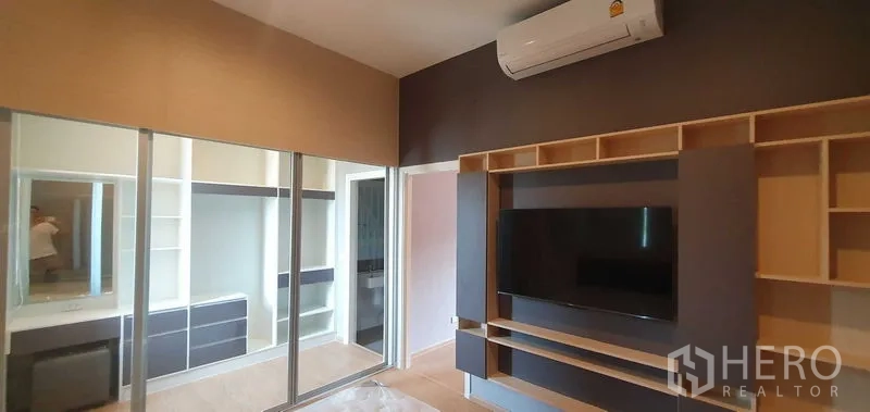 带办公室的家 出租在Prawet, Bangkok - 主卧配壁挂电视墙、镜面衣柜与梳妆台，并带空调。