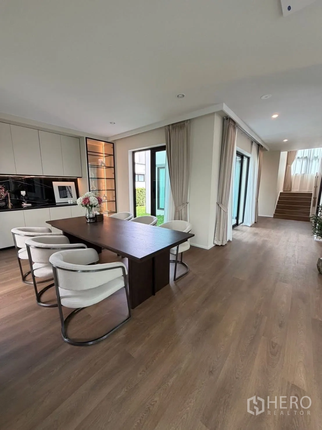 บ้านเดี่ยว for rent in Bang Phli, Samut Prakan - โถงรับประทานอาหารแบบเปิดโล่ง ประตูเลื่อนออกสู่สวน และทางเดินไปบันได