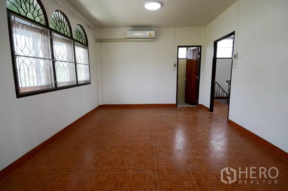 带办公室的家 出租在Lat Phrao, Bangkok - 明亮的二楼房间，拱形窗配防盗格、空调与瓷砖地面。