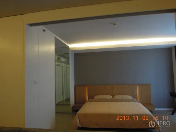 公寓 出租在Watthana, Bangkok - 温馨卧室，配大床、灯带与镜面衣柜的曼谷公寓