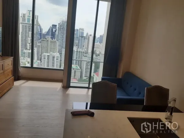Condominium for rent or sale in Watthana, Bangkok - Bright living area with floor-to-ceiling windows and skyline view at The Esse condo.