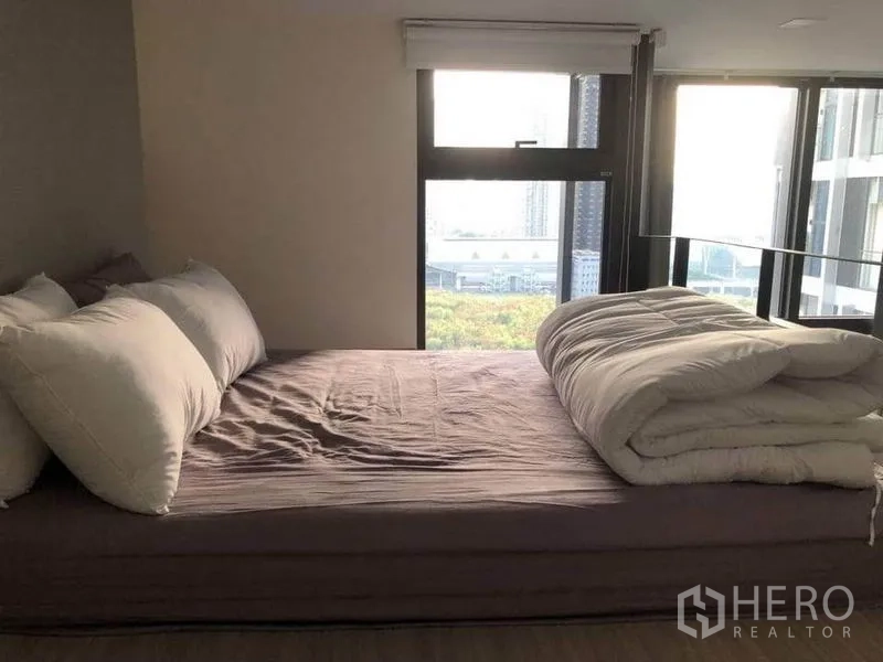 公寓 出售在Ratchathewi, Bangkok - 卧室临落地窗，享城市景观与充足阳光的双人床。