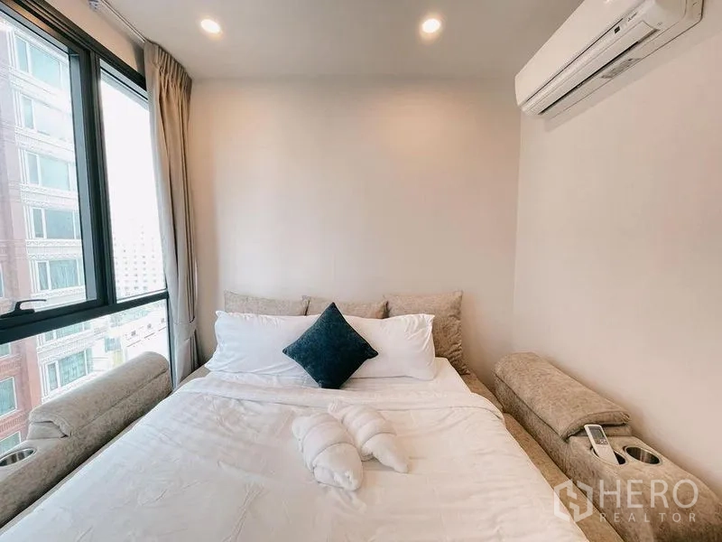 Condominium for rent in Ratchathewi, Bangkok - Cozy bedroom with double bed, air conditioner and large window.