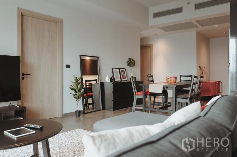 คอนโด ให้เช่าในWatthana, Bangkok - มุมมองสู่ห้องนั่งเล่นกว้างเชื่อมพื้นที่ทานข้าว ประตูไม้โทนอ่อนและของตกแต่ง