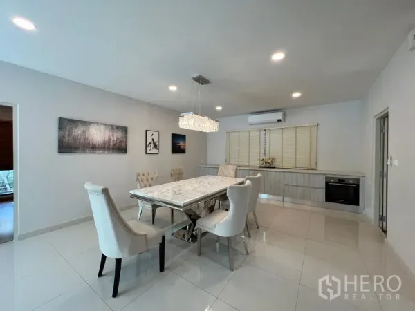 Detached House for rent in Bang Phli, Samut Prakan - Bright dining room with crystal chandelier, wall art and built-in sideboard.