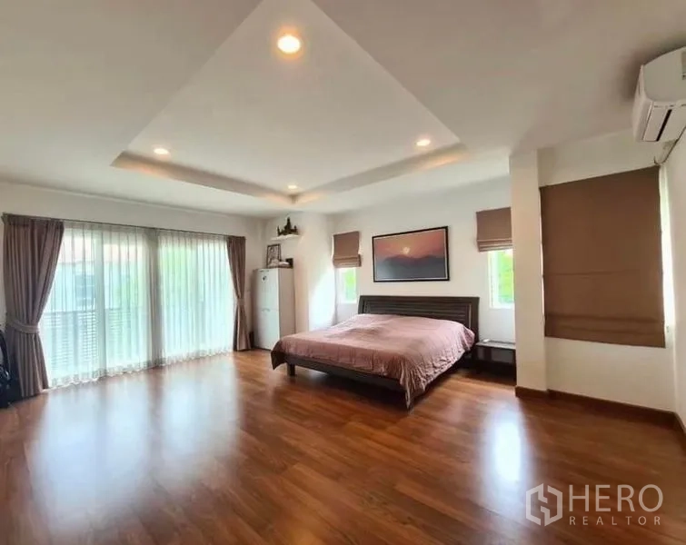Detached House for rent or sale in Lat Krabang, Bangkok - Large master bedroom with wood flooring, recessed ceiling lights and wide windows.