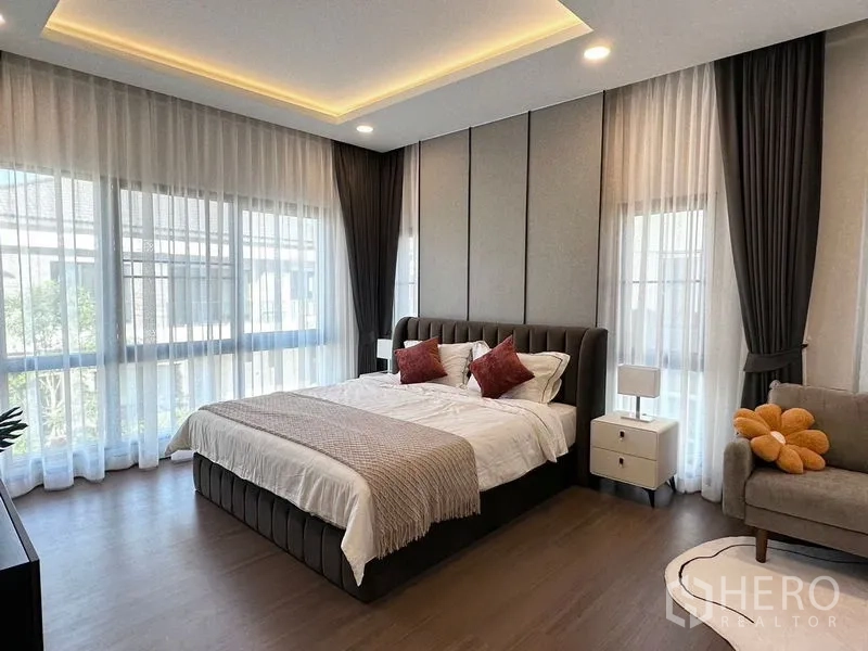 Detached House for rent or sale in Bang Phli, Samut Prakan - Master bedroom with large corner windows and layered curtains.