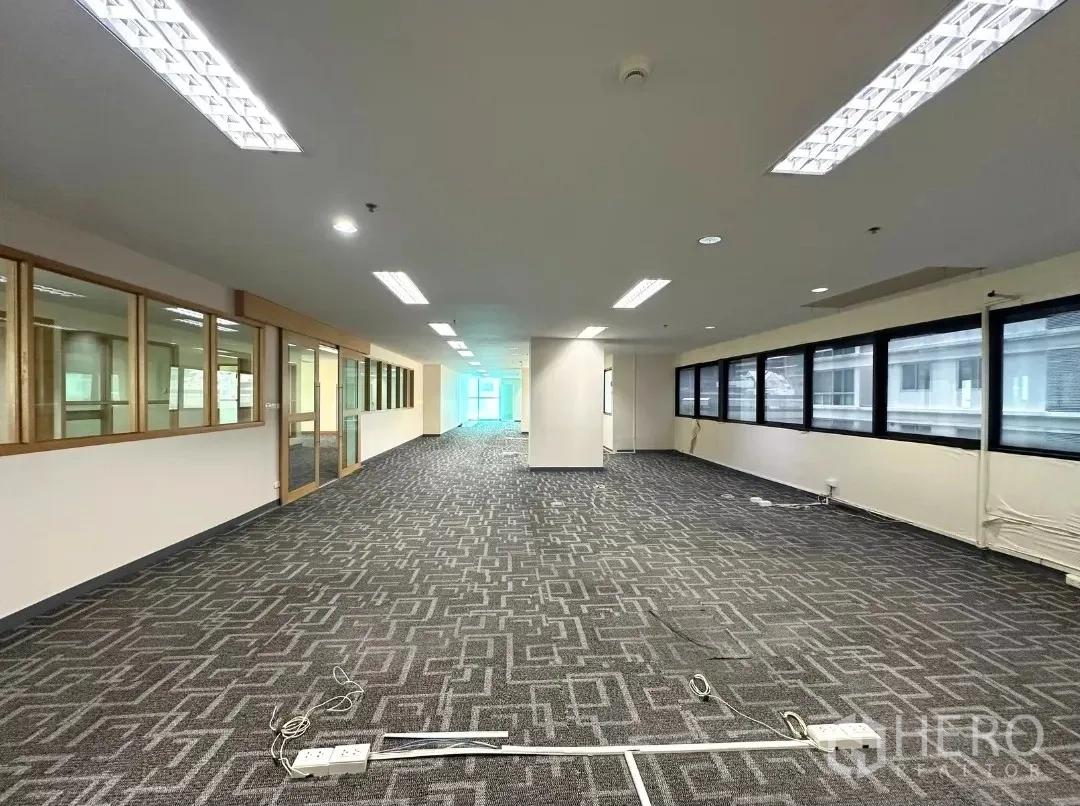 Office Space for rent in Bang Rak, Bangkok - Deep floor plate with patterned carpet and windows along both sides.