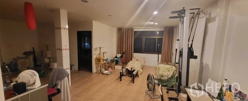 Shophouse for rent in Khlong Toei, Bangkok - Multi-purpose living space with windows, curtains and exercise machine.