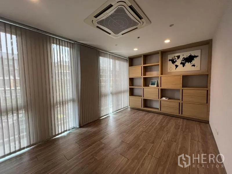 带办公室的家 出租在Bueng Kum, Bangkok - 转角办公室，整墙书柜、百叶窗与嵌入空调。