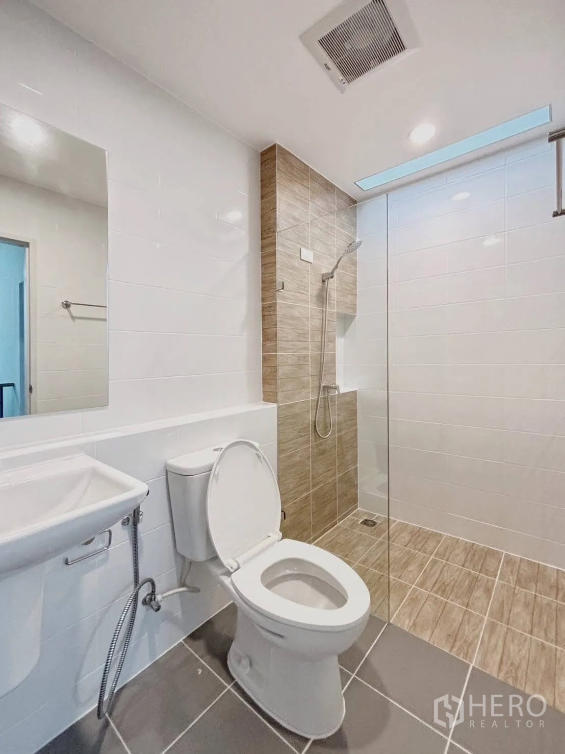 Townhouse for rent in Bang Phli, Samut Prakan - Bright bathroom with glass-partition shower, toilet, and basin.