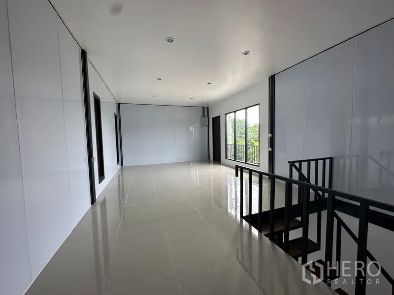 Warehouse for rent or sale in Lam Luk Ka, Pathum Thani - Bright mezzanine office with tiled floors, windows, and railing overlooking the floor.