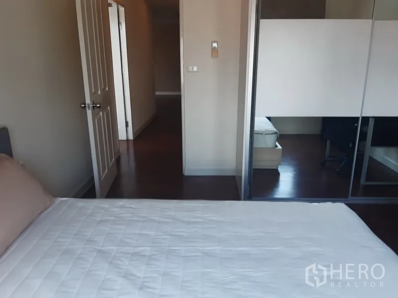 Condominium for rent in Khlong Toei, Bangkok - Second bedroom showing sliding wardrobe doors and corridor access.